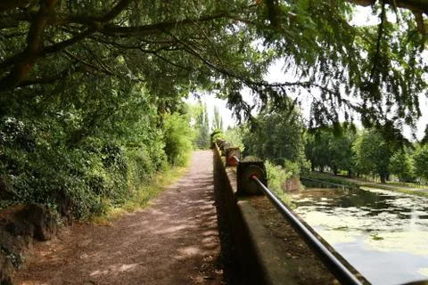 Path under the green trees with water and barrier France Metz Foto stock