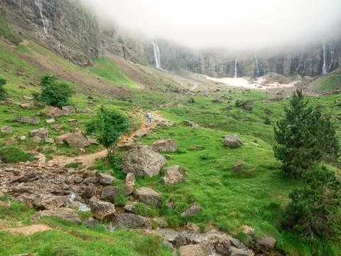 The path in the valley between the mountains with the figure of a lonely man Stock Photos