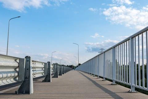 Path walking along road sheltered by barriers and grate Foto stock