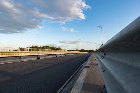 Path walking along road sheltered by barriers and grate Foto stock