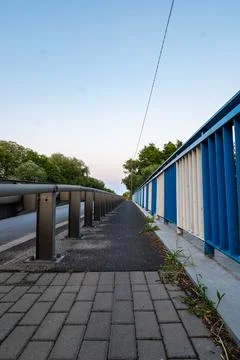Path walking along road sheltered by barriers and grate Stock-Fotos