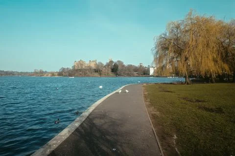 Path for walking on the lake going to an ancient palace on a sunny spring day Stock Photos