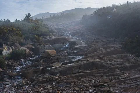 Path of water runing down the rocks between the mist in a trail 写真素材