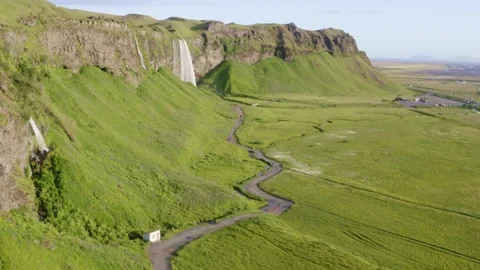 Path way along the cliff with waterfall Seljalandsfoss and people walking Stock Footage