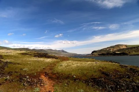  A path winding through a grassy high desert landscape with hill Stock Photos