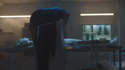 A Pathologist examining woman's cadaver on the table Stock Footage 283146139