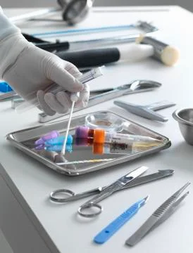 Pathologist taking a DNA sample for analysis during a autopsy Stock Photos