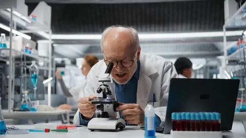 Pathology technician analyzing cellular structures using professional microscope Stockfoto's