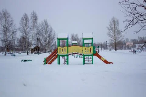 Paths in the winter Park. Bench, Playground for children. Stock Photos