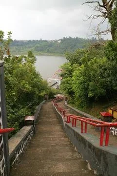 Pathway along a river with trees and hills in the background Stock Photos
