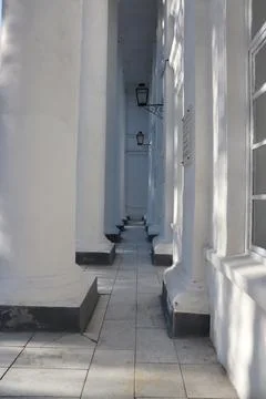 Pathway between white columns at a building with architectural details during Stock Photos