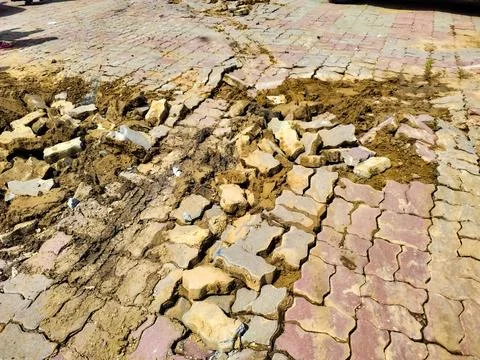 A pathway with damaged tiles due to poor installation quality. Stock Photos