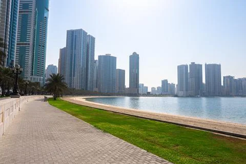 Pathway in modern park with city skyline view Stock Photos
