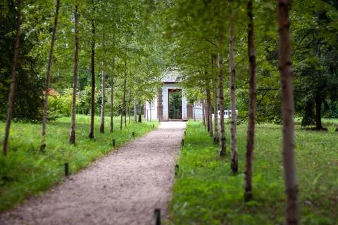 Pathway through the trees with building at end Stock Photos