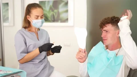 The patient actively talks about his problems to the dentist Video stock 167303623