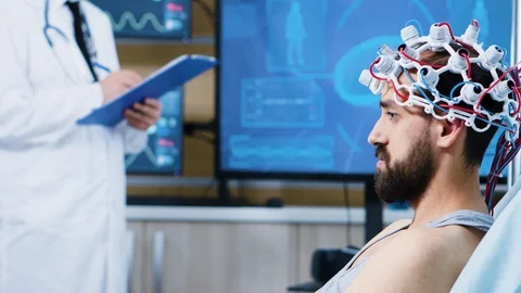 Patient with brainwaves scanning headset sitting on bed Video stock 119764980