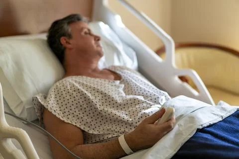Patient calling for nurse with remote control in hospital bed Stock Photos