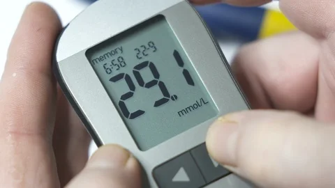 Patient with diabetes using blood glucose meter. Viewing blood glucose results Stock Footage