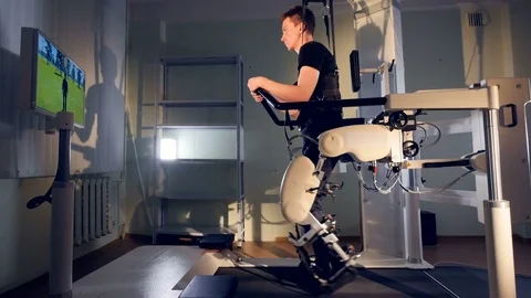 A patient during robot-assisted therapy with the Lokomat device Video stock 76228345