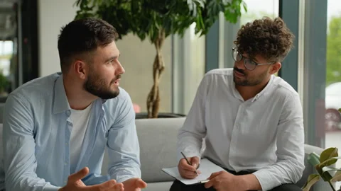 Patient explaining problems to attentive psychiatrist taking notes Stock Footage 316726005