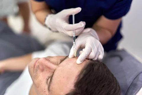 Patient getting a shot of botox in the forehead Stock Photos