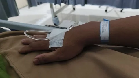 Patient hand with iv drip after surgery in the hospital bed 스톡 동영상 346754320
