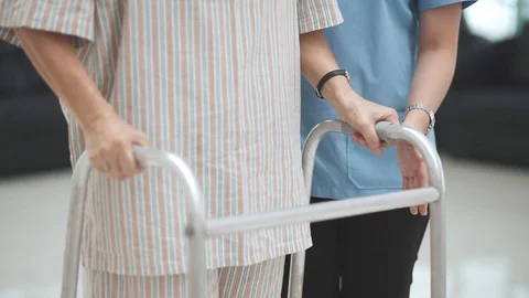  patient learning to use walker with physical therapist	 Stock Footage 130130525