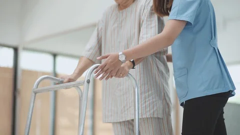 Patient learning to use walker with physical therapist	 Stock Footage 130130535