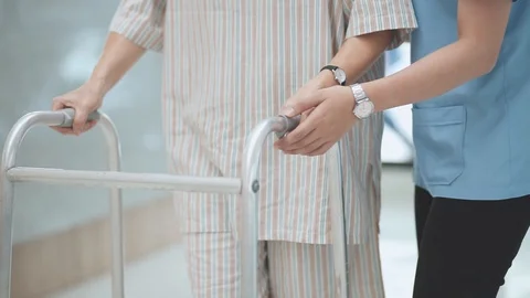 Patient learning to use walker with physical therapist	 Stock Footage 130130550