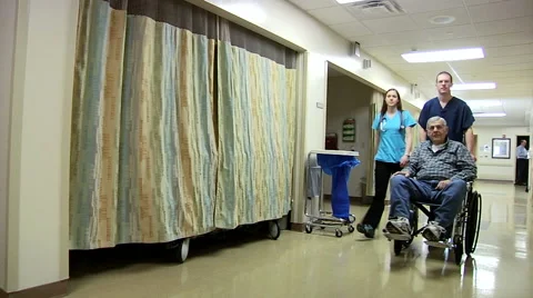 Patient Leaving Hospital In Wheel Chair With Nursing Staff Stock Footage