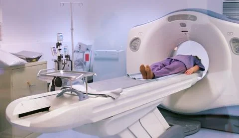 A patient lies on a table while undergoing a CT scan in a medical facility. T Stock-Fotos