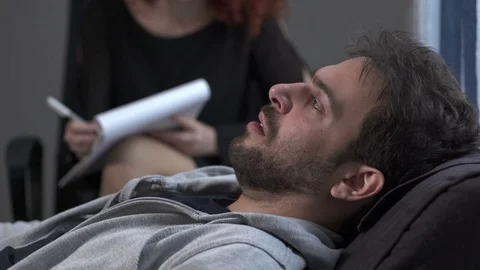 Patient lying on the couch while talking with the psychologist Stock-Footage 71036819