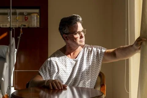 Patient pulling back curtain to view the outside Stock Photos
