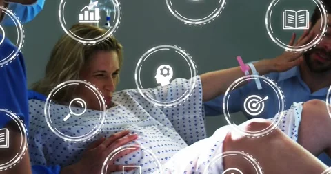 Patient pushing amid contraction on bed, partner wiping brow, nurse adjusting Stock Footage 329561359