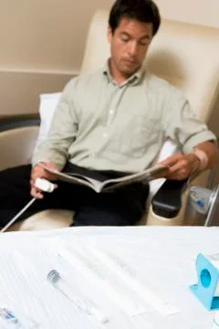 Patient Reading A Magazine While Being Monitored Stock Photos