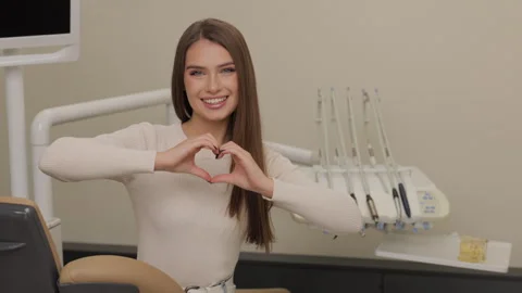 Patient is smiling and gesturing hands heart in dentist office Stock Footage 319345184