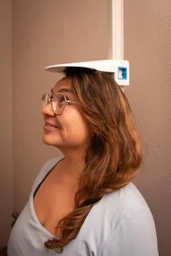 Patient standing beneath stadiometer for height measurement Foto stock