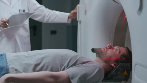 Patient Undergoing CT Scan Procedure as Technician Operating Control Panel Video stock 335255595