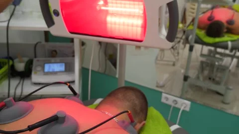A patient undergoing an electrotherapy with the infrared therapy Stock Footage 275826535