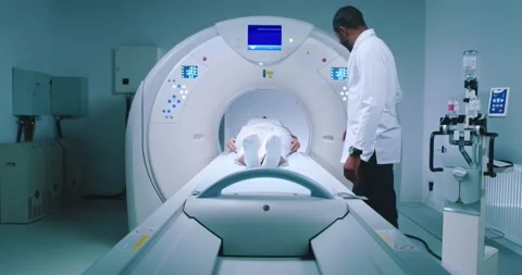 Patient is undergoing MRI procedure. Multucultural medical worker performs Stock Footage 243607890