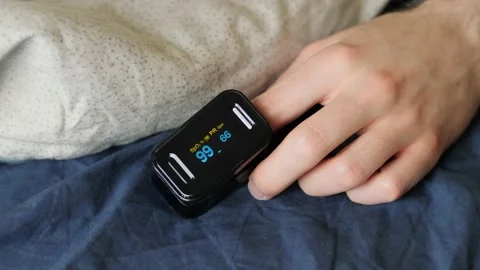 Patient using pulse oximeter at home closeup Video stock 152929665