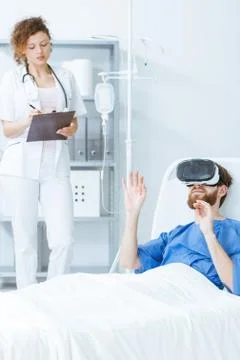 Patient in VR lying in bed 库存照片