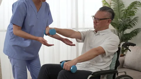 Patient on wheelchair exercises with nurse's help Stock Footage 204789247