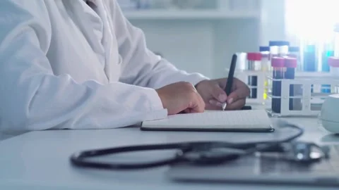 Patient at worktable. Close up elderly female doctor writing notes in Stock-Footage 336588354