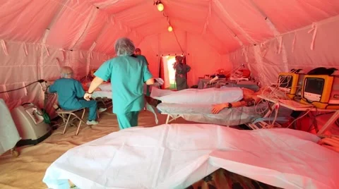 Patients in beds and doctors in tent during special tactical teachings Stock Footage 65183211