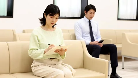 Patients Filling Out Forms and Using Smartphone in Hospital Waiting Room Stock-Footage 344237147