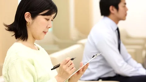 Patients Filling Out Forms and Using Smartphone in Hospital Waiting Room Video stock 344237212
