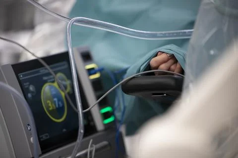 A patient's hand appears through a sheet in the operating room Stock Photos
