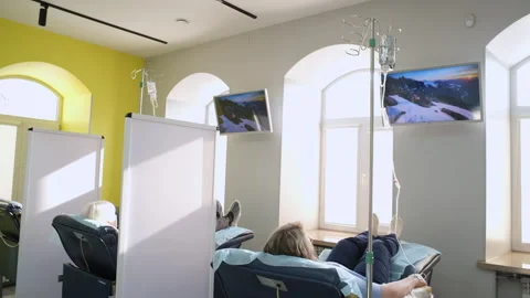 Patients lie on couches while receiving chemotherapy or other medication. Video stock 249666221