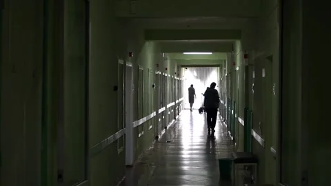 Patients in silhouette  walking down a dark hospital corridor Stock Footage 204990784